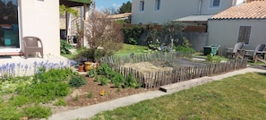 A garden with a wooden fence, potted plants, and a patio area with outdoor furniture. - Bed and Breakfast 'Chambre 1' with Private Terrace and Wi-Fi (Les Sables-d'Olonne)