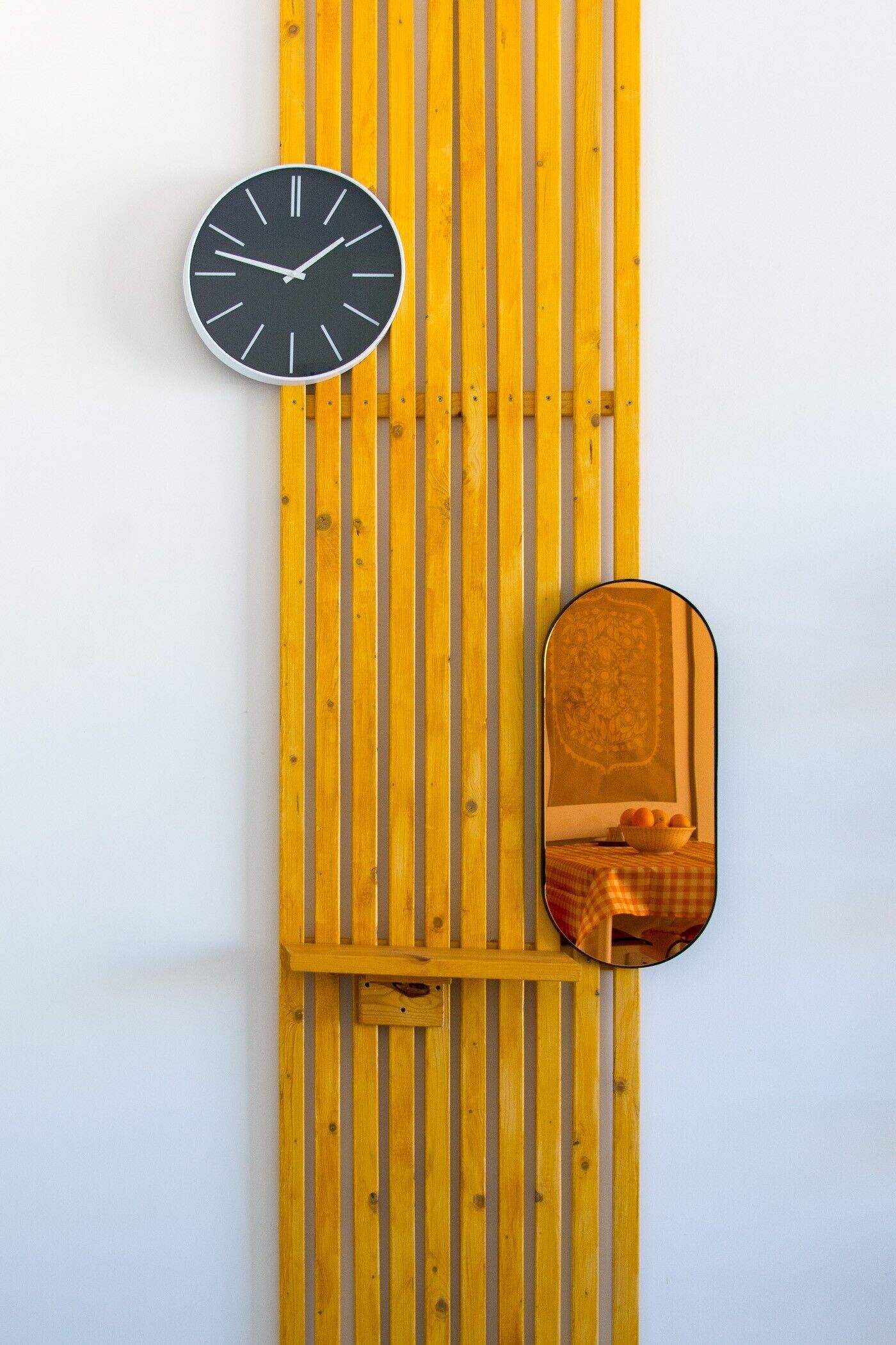 A wall-mounted clock and a mirror with a decorative frame.