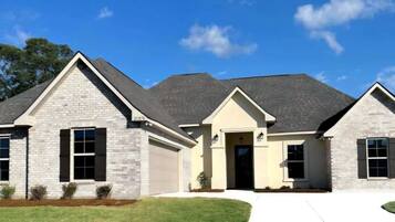A two-story house with a brick facade, a front entrance, and a driveway.
