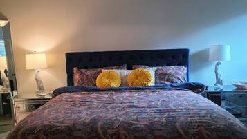 A bedroom with a bed, a ceiling fan, and two bedside lamps.
