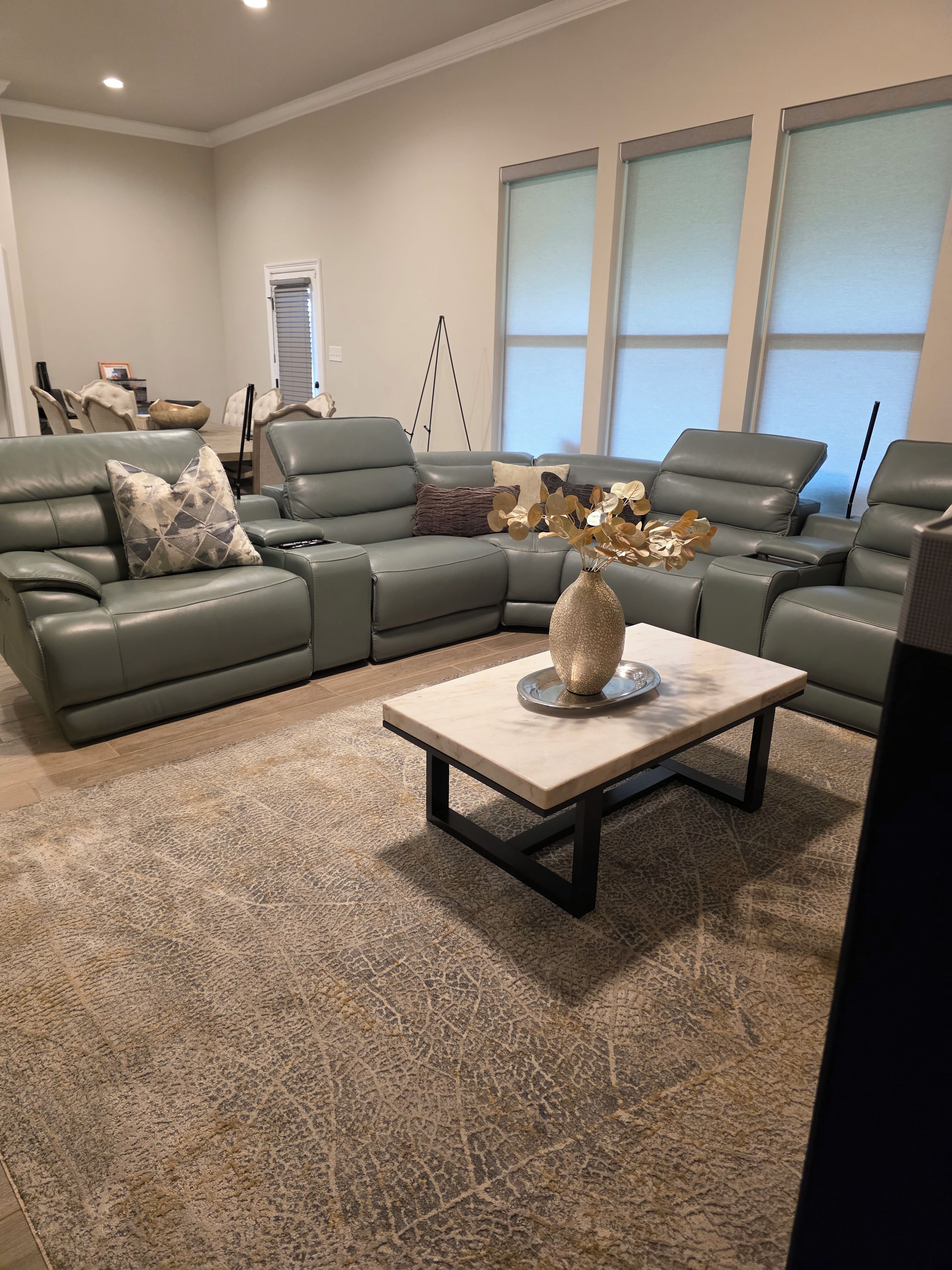 Una sala moderna con un sofá modular, una mesa de centro y un jarrón decorativo.