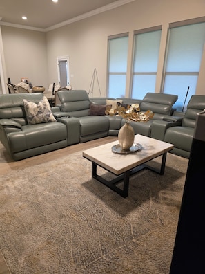 Una sala moderna con un sofá modular, una mesa de centro y un jarrón decorativo.