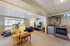 Een knus leefruimte met een bank, televisie en een kleine kitchenette.
