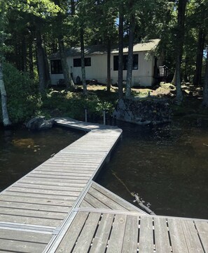 A wooden dock extending into a body of water with a house in the background surrounded by trees. - Updated 3BR Lakefront Dog Friendly - Washer Dryer (Moultonborough)