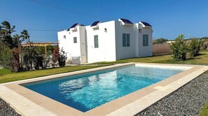 A modern two-story house with a rectangular swimming pool in front. - Beach Lote Villas- Entire Property- Islote (Arecibo)