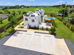 A residential property with a swimming pool, solar panels, and a parking area. - Beach Lote Villas- Entire Property- Islote (Arecibo)