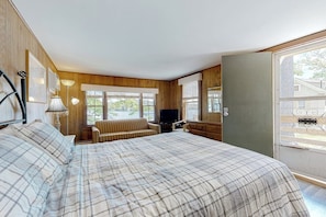 A bedroom with a bed, a television, a sofa, and a window. - Picturesque Studio Lakefront - Dock (Alton)