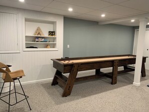 Una mesa de billar en una habitación con pared azul claro y puerta blanca.