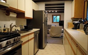A compact kitchen with a stove, sink, and refrigerator.