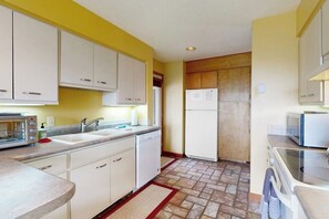 A kitchen with white cabinets, a microwave, a refrigerator, and a dishwasher. - Lake-view 2BR with lakefront swimming, pools (Gilford)