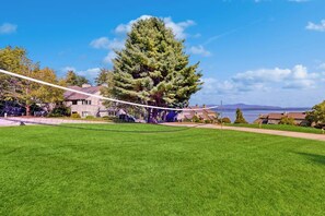 A grassy area with a rope swing, houses in the background, and a clear sky. - 2BR condo with pool and tennis (Gilford)