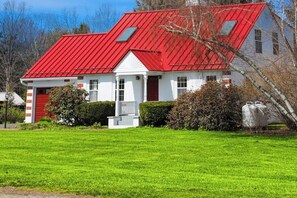 A two-story house with a red roof, white walls, and a front porch. - Updated 3BR Dog Friendly - Deck - Garage Parking (Gilford)