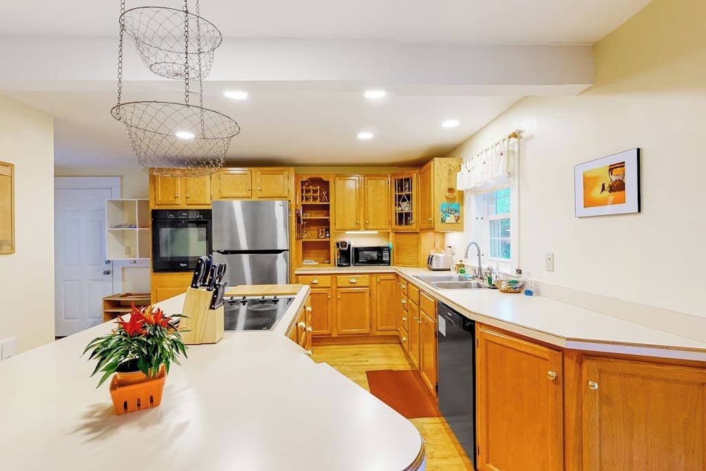 A modern kitchen with wooden cabinets, stainless steel appliances, and a central island.