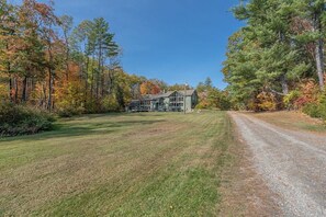 A house with a gravel driveway and a lawn in front.