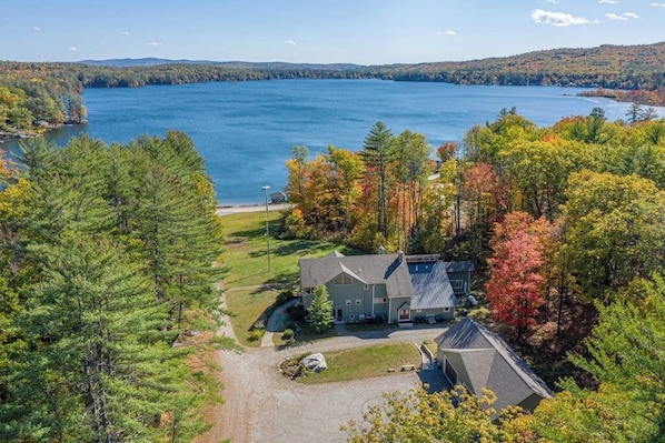 A house with a large front yard and a view of a lake.