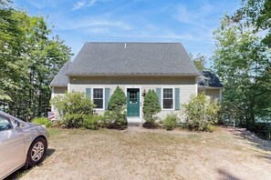 A single-story house with a green door, white siding, and a dark roof. - Scenic 2BR Lakefront - Washer Dryer (Meredith)