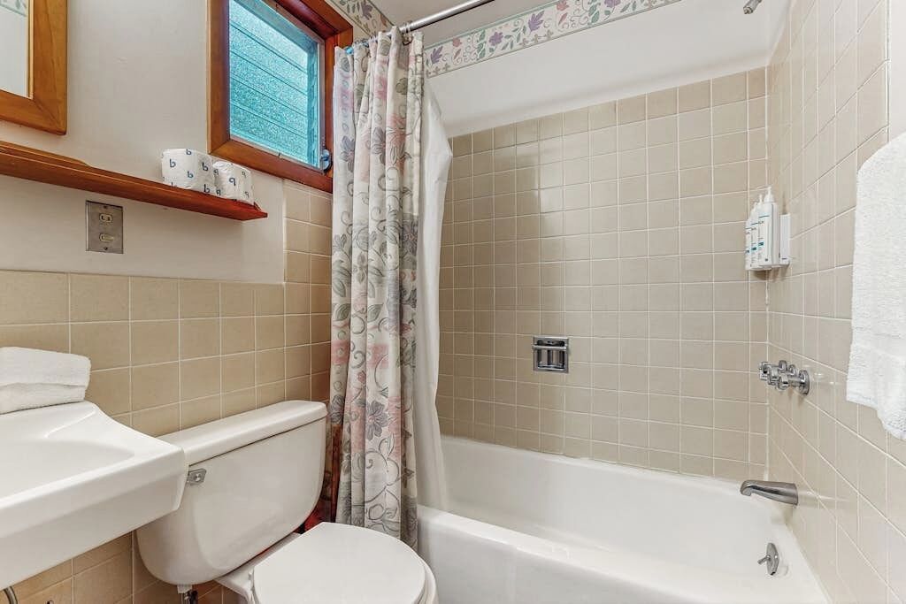 Une salle de bain avec des toilettes, un lavabo et une baignoire.