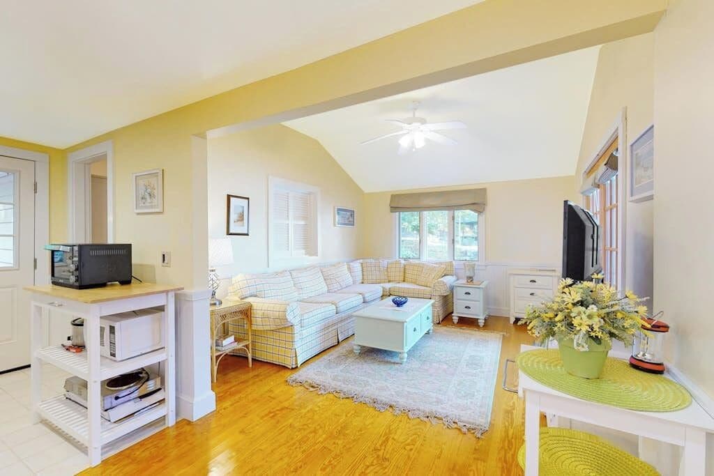 A living room with a sofa, a coffee table, a TV, and a bookshelf.