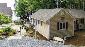 A small, single-story building with a sloped roof, a sign indicating a restaurant, and a paved pathway leading to it. - Stunning 1BR Lakefront - Dock - Deck (Moultonborough)