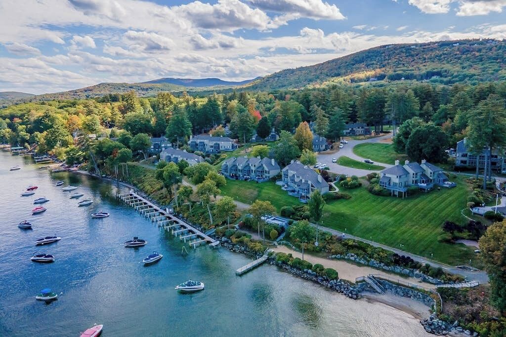 A lakeside residential area with houses, a dock, and boats.