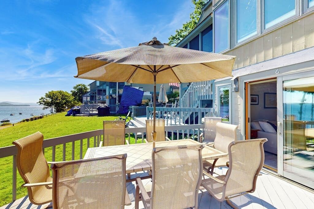 Een terras met tuinmeubilair en uitzicht op de oceaan.