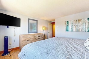 A bedroom with a bed, a dresser, a flat-screen TV, and a painting on the wall. - 3BR Samoset Lakefront Townhouse (Gilford)