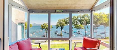 Un área de estar al aire libre con techo, con vista al mar y a los barcos.