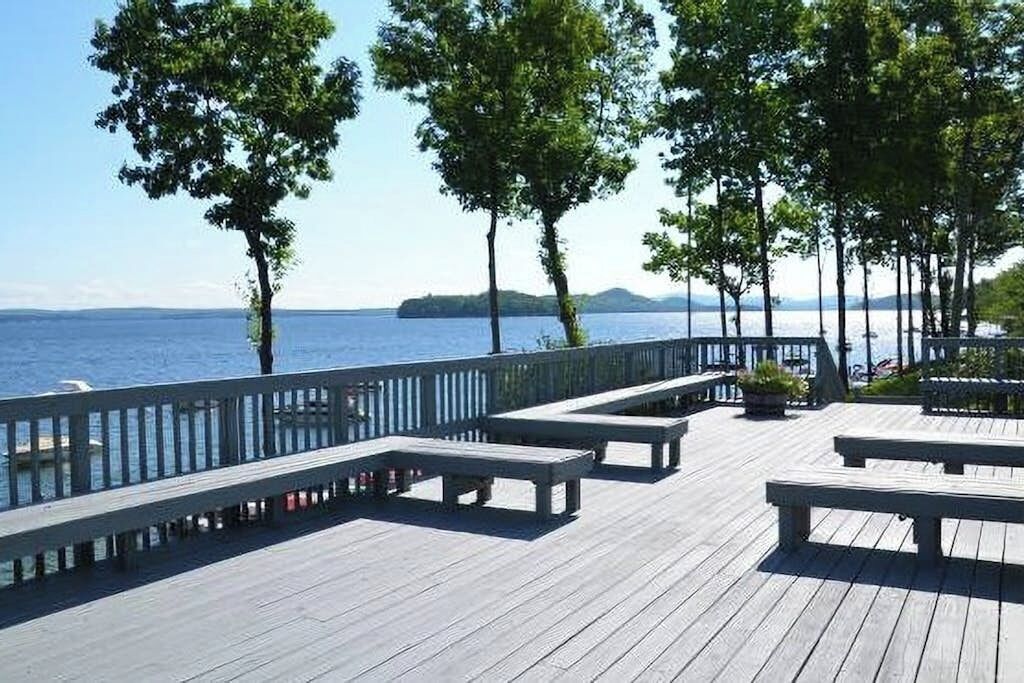 A wooden deck with benches overlooking a body of water.