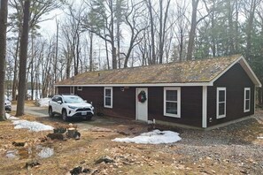 Einbungalow mit Satteldach, Eingangstür und Garage.