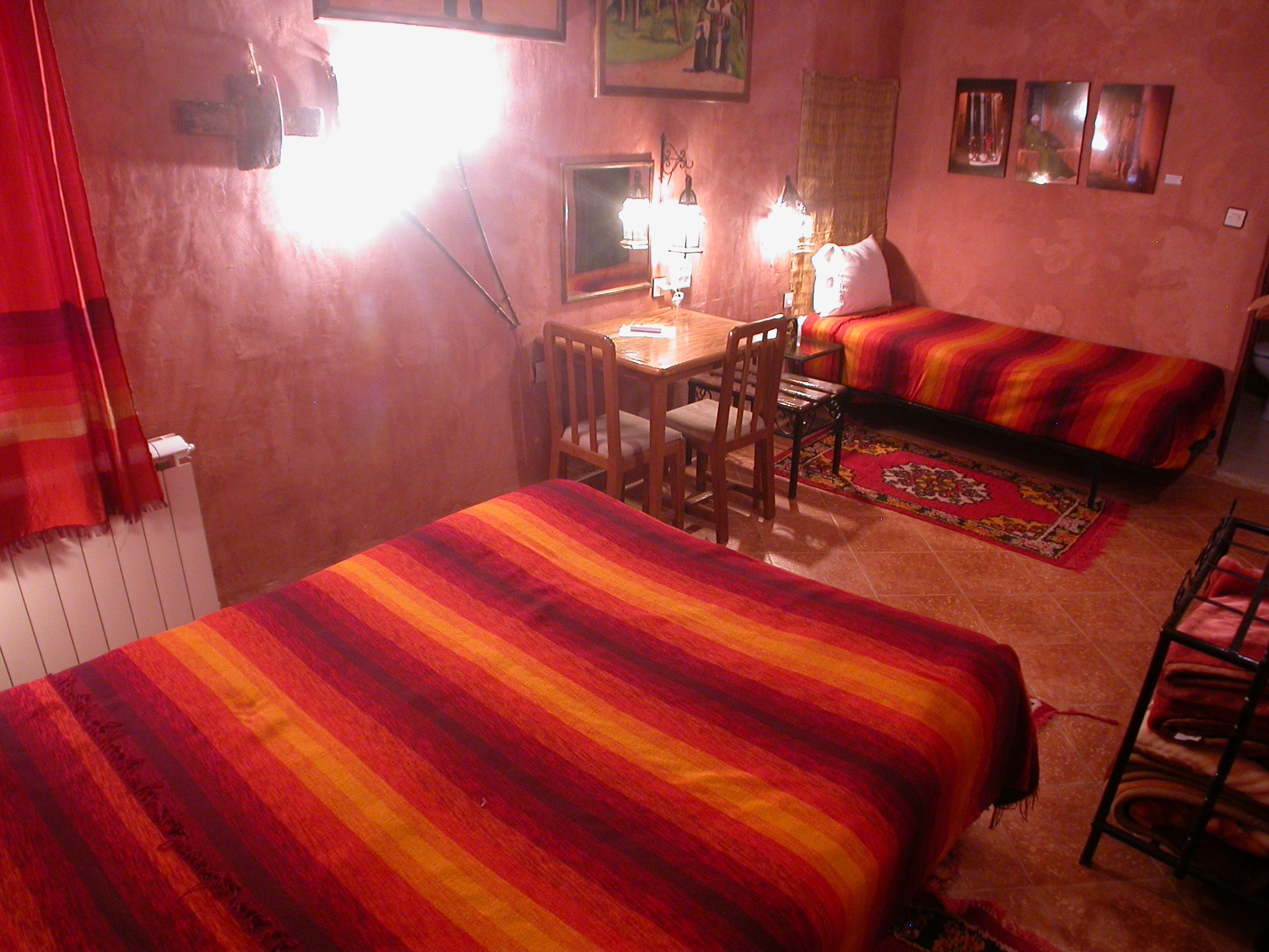 Una habitación con dos camas, un escritorio y una silla.
