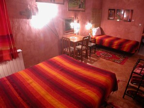 Una habitación con dos camas, un escritorio y una silla.