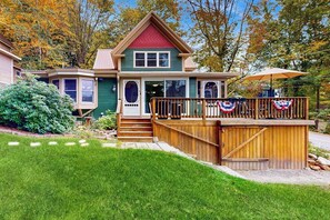 A two-story house with a front deck and a covered porch.