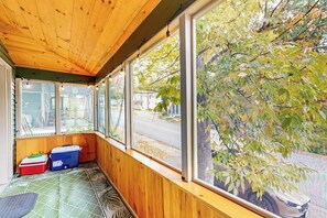 A room with large windows, wooden ceiling, and a green patterned floor.