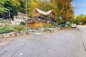 A two-story house with a porch, stone steps, and a flag. - 4BR charming central cottage, walk to lake & town (Alton)