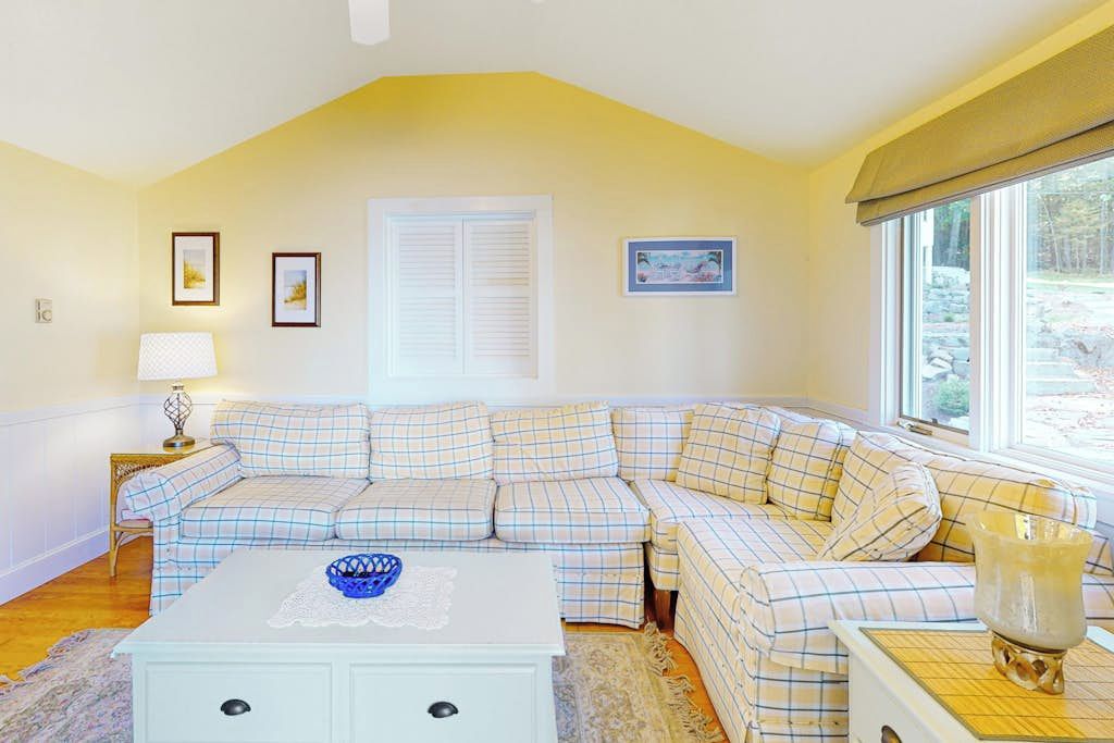 A cozy living room with a sectional sofa, a coffee table, and a window with a view.