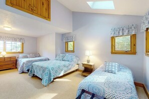 A bedroom with two beds, a wooden dresser, a nightstand, and a skylight. - Stunning 3BR Lakefront - Dock - Deck - Washer Dryer (Moultonborough)