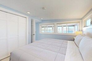 Ein Schlafzimmer mit Bett, Fenster und Tür.