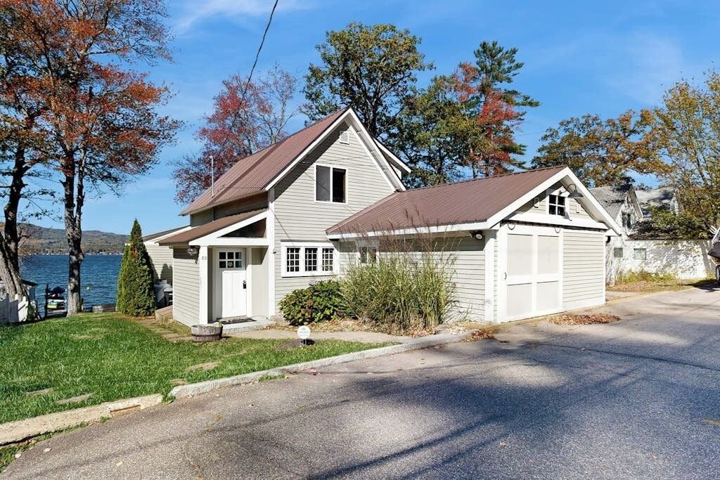 A two-story house with a garage, a front porch, and a small front yard.
