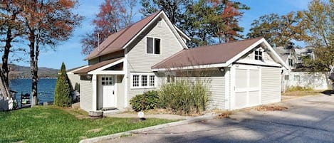 Ein zweistöckiges Haus mit Garage, Veranda und kleinem Vorgarten.