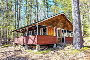 A wooden cabin with a porch, surrounded by trees. - Cozy 2BR Dog Friendly - Beach Down the street (Moultonborough)