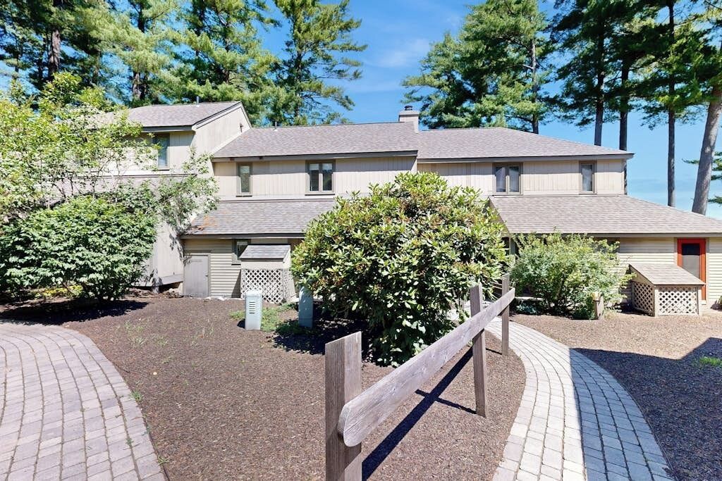 A two-story building with a paved driveway and a wooden fence.