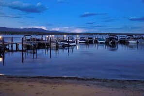A calm lake with boats docked at wooden piers, surrounded by mountains. - 3BR - Dock - Fireplace - Deck - Tennis (Meredith)