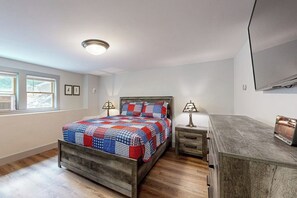 A bedroom with a bed, bedside tables, a dresser, a ceiling light, and a window. - 4BR Beautiful renovated home, centrally Located (Gilford)