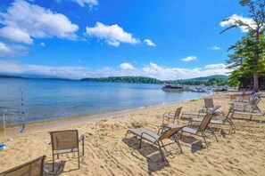 Une plage bordée de rangées de transats et une mer calme.