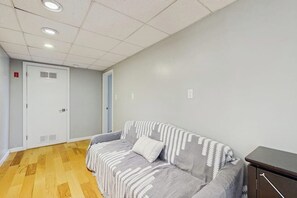 A room with a sofa, a cabinet, and a door. - 3BR stunning home with views, pool & lake access (Meredith)