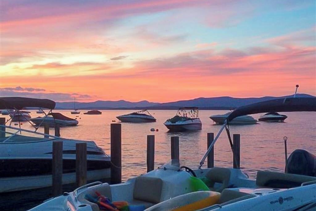 A marina with boats docked at wooden piers during sunset.