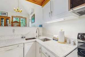 A kitchen with white cabinetry, a built-in dishwasher, a stainless steel range, and a chandelier. - 3BR withbeach, pool, tennis, game room, porch &views (Gilford)