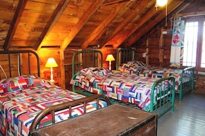 A cabin with three bunk beds, wooden beams, and a window with a curtain. - Charming 3BR Lakefront Dog Friendly (Moultonborough)