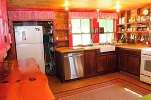 A kitchen with wooden cabinets, a refrigerator, a dishwasher, and a stove. - Charming 3BR Lakefront Dog Friendly (Moultonborough)