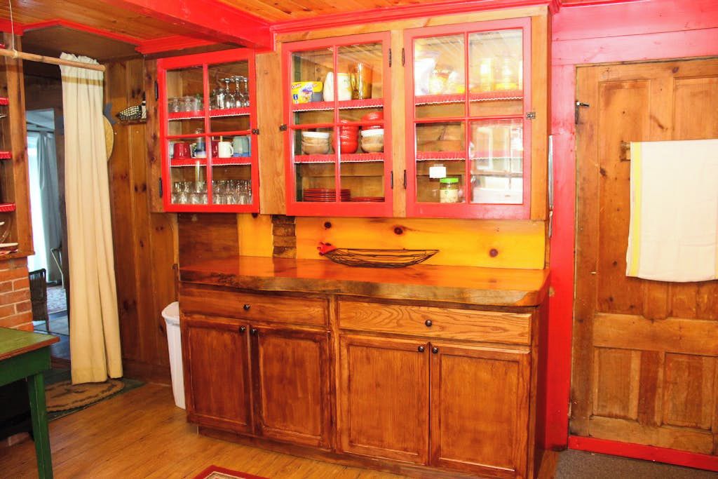 Eine Holz-Küche mit einem roten Schrank und einer Holz-Arbeitsplatte.